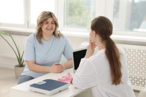 Weight loss. Nutritionist consulting overweight woman at white d