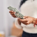 African american woman counting dollars at new home