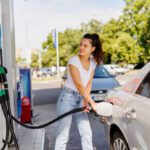Upset woman refueling the gas tank at fuel pump