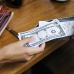 Woman paying cash for bill restaurant