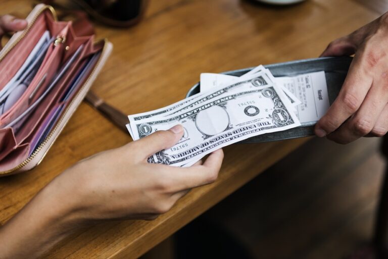 Woman paying cash for bill restaurant